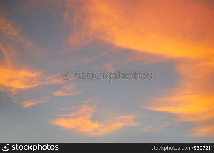 Sunset sky with orange golden clouds on blue background