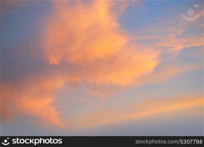 Sunset sky with orange golden clouds on blue background