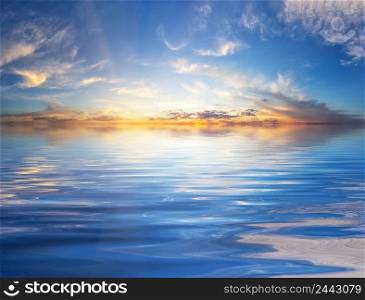 Sunset sky with sunbeams over the water surface. Sunset sky with sunbeams over water surface