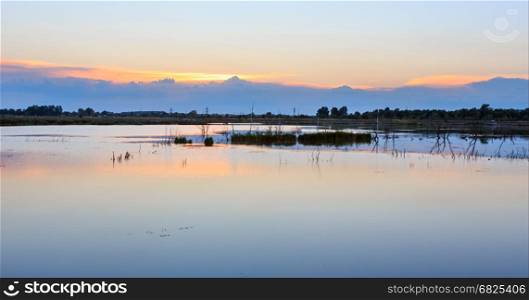 Sunset summer lake landscape with sun reflection on water surface (near Shklo settlement, Lviv Oblast, Ukraine).