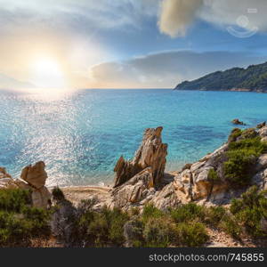 Sunset summer sandy beach and rocky coast near Platanitsi Beach, Sithonia Peninsula, Chalcidice, Greece.