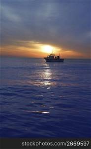 sunset sunrise with fishing boat in horizon blue mediterranean sea