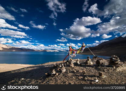 Sunset view at Tso Moriri Lake with stone pyramid and Buddhist praying flags. Himalaya mountains landscape. India, Ladakh, altitude 4600 m