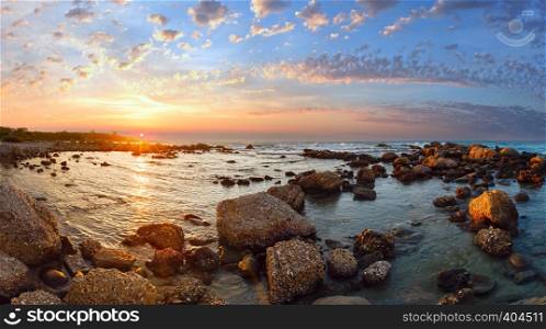 Sunset view from stony beach. Summer coastline (Greece, Zakynthos, Alykes, Ionian Sea).