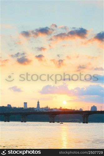 Sunset view of Mother Motherland monument, motor boat on Dnipro river, Paton bridge. Kiev, Ukraine