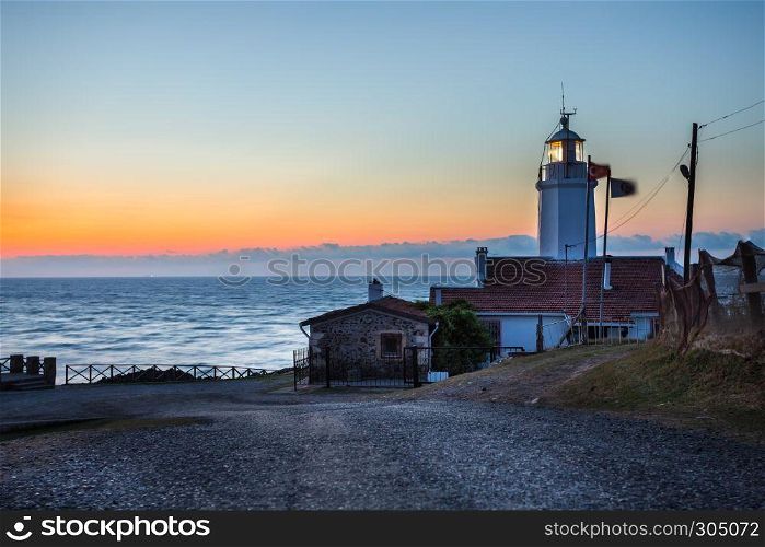 Sunset view of old white Inceburun lighthouse on the north coast of Sinop,Turkey.. Landscape view of old white Inceburun lighthouse