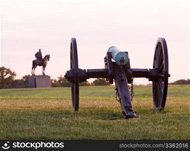 Sunset view of the old cannons in a line at Manassas Civil War battlefield where the Bull Run battle was fought. Stonewall Jackson statue is in the distance. 2011 is the sesquicentennial of the battle