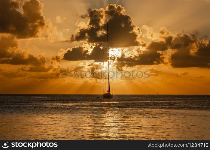 Sunset view of yacht anchored in the lagoon, Britannia bay, Mustique island, Saint Vincent and the Grenadines, Caribbean sea