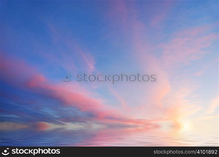 Sunset with purple clouds and blue sky reflecting in water.