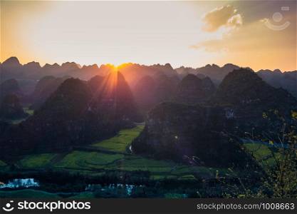 Sunset with Rapeseed flower field at Wanfenglin National Geological Park (Forest of Ten Thousands Peaks), China