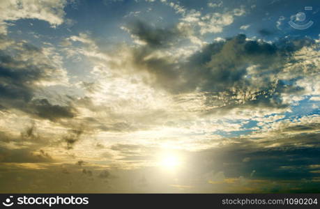 Sunset with sun rays, sky with clouds and sun.