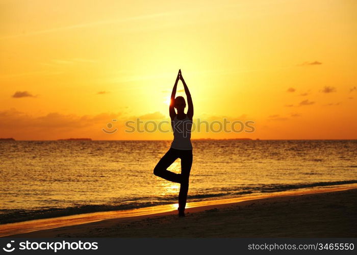 sunset yoga woman on sea coast