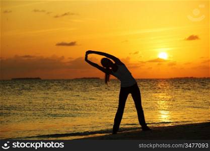 sunset yoga woman on sea coast