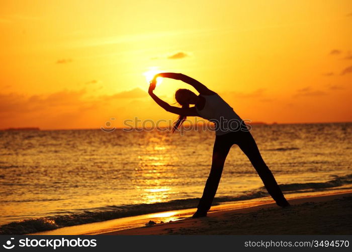 sunset yoga woman on sea coast