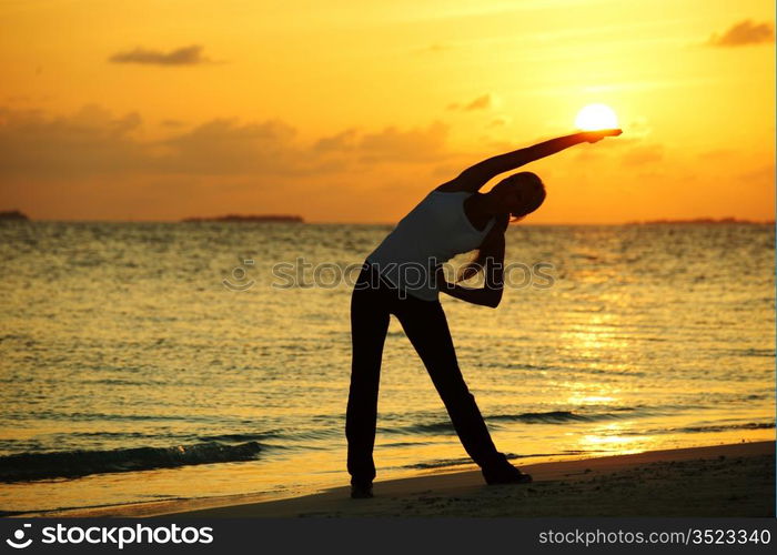 sunset yoga woman on sea coast