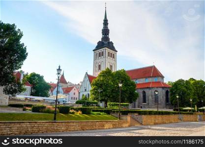 Sunshine Old Town skyline with St. Nicholas church and green park, Tallinn, Estonia