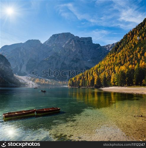 Sunshiny autumn peaceful alpine lake Braies or Pragser Wildsee. Fanes-Sennes-Prags national park, South Tyrol, Dolomites Alps, Italy, Europe. People are unrecognizable.