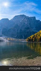 Sunshiny autumn peaceful alpine lake Braies or Pragser Wildsee. Fanes-Sennes-Prags national park, South Tyrol, Dolomites Alps, Italy, Europe. People are unrecognizable.