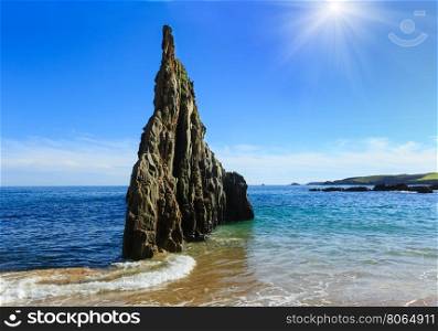 Sunshiny Sandy Mexota beach and pointed rock (Spain). Atlantic Ocean coastline landscape.