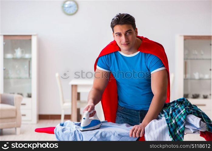 Super hero man husband ironing at home