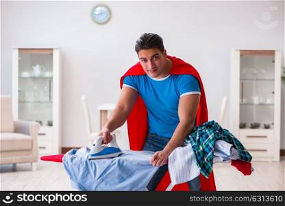 Super hero man husband ironing at home