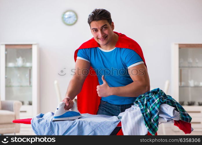 Super hero man husband ironing at home