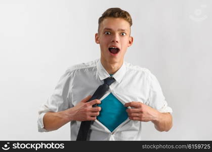 super hero suit of business man. Young businessman showing suit of super hero with copy space under his shirt and tie on gray background