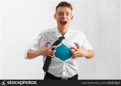 super hero suit of business man. Young businessman showing suit of super hero with copy space under his shirt and tie on gray background