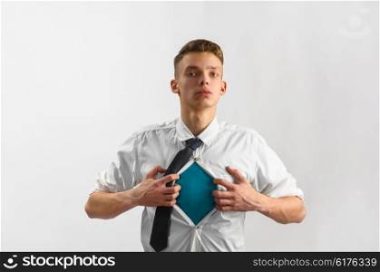 super hero suit of business man. Young businessman showing suit of super hero with copy space under his shirt and tie on gray background