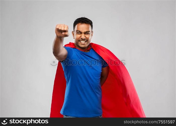 super power and people concept - flying indian man in red superhero cape flying over grey background. indian man in superhero cape flying over grey