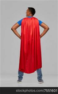 super power and people concept - happy smiling indian man in red superhero cape with arms on hips over grey background. happy smiling indian man in red superhero cape