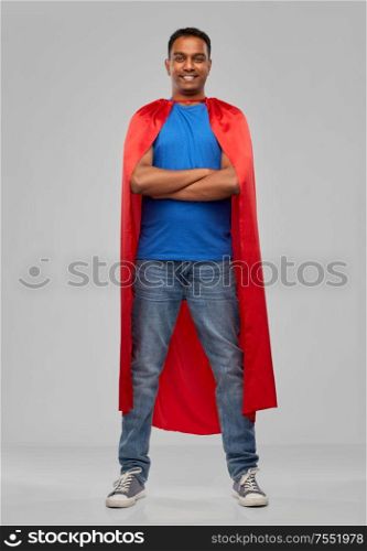super power and people concept - happy smiling indian man in red superhero cape with arms crossed over grey background. indian man in red superhero cape with arms crossed