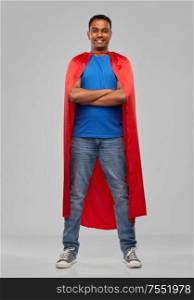 super power and people concept - happy smiling indian man in red superhero cape with arms crossed over grey background. indian man in red superhero cape with arms crossed