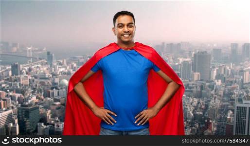super power and people concept - happy smiling indian man in red superhero cape with arms on hips over tokyo city background. happy indian man in superhero cape in tokyo city