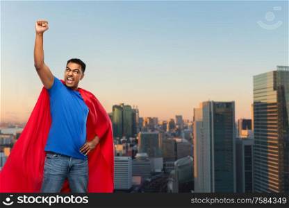 super power and people concept - indian man in red superhero cape making winning gesture over sunset in tokyo city background. indian superhero makes winning gesture in city