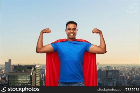 super power and people concept - indian man in red superhero cape showing his muscles over tokyo city background. indian man in superhero cape showing his power