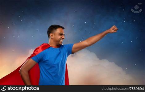 super power and people concept - indian man in red superhero cape making winning gesture over starry night sky background. indian man in superhero cape makes winning gesture
