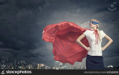 Super woman. Young confident woman in red cape and mask