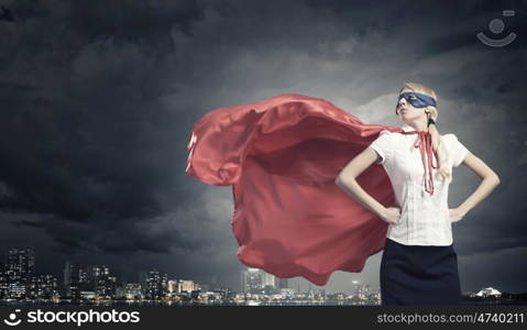 Super woman. Young confident woman in red cape and mask