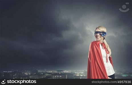 Super woman. Young confident woman in red cape and mask