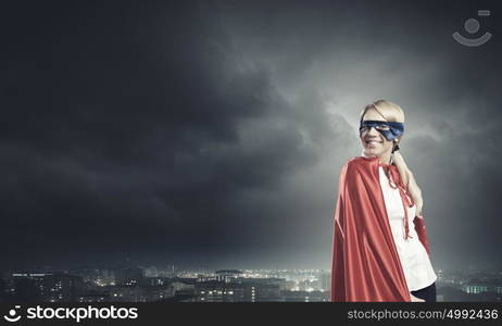 Super woman. Young confident woman in red cape and mask