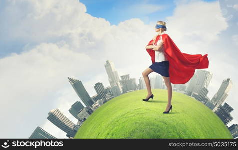 Super woman. Young confident woman in red cape and mask