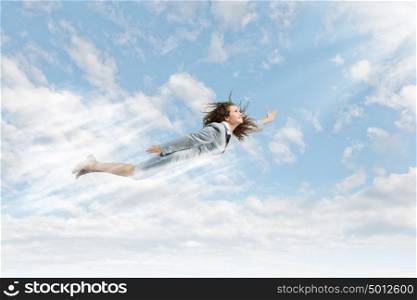 Super woman. Young happy businesswoman flying high in sky