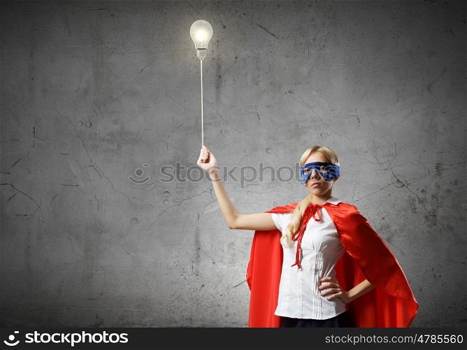 Super woman. Young woman in super hero costume with bulb balloon in hand