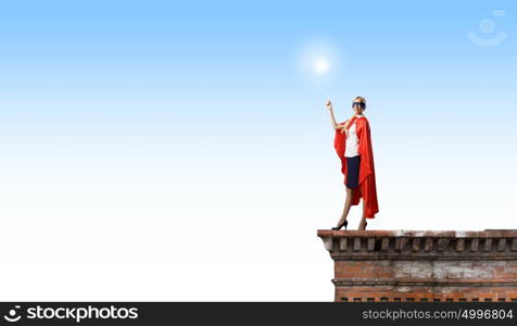 Super woman. Young woman in super hero costume with bulb balloon in hand