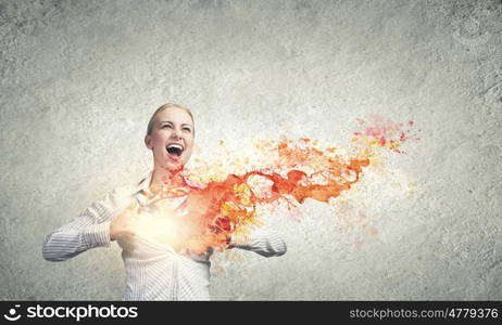 Super woman. Young woman tearing shirt on chest and splashes flying out