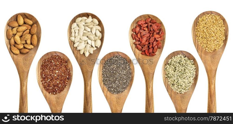 superfood abstract - isolated wooden spoons with almonds, red quinoa grain, pumpkin seeds, chia seeds, goji berry, hemp seed hearts, and golden flax seed