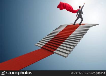 Superhero businessman climbing red carpet stairs