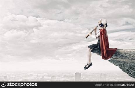 Superkid with spyglass. Cute supergirl of school age with looking in spyglass