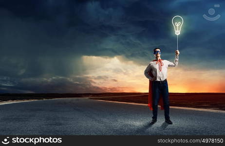 Superman with balloon. Young man in superhero costume holding balloon in hand